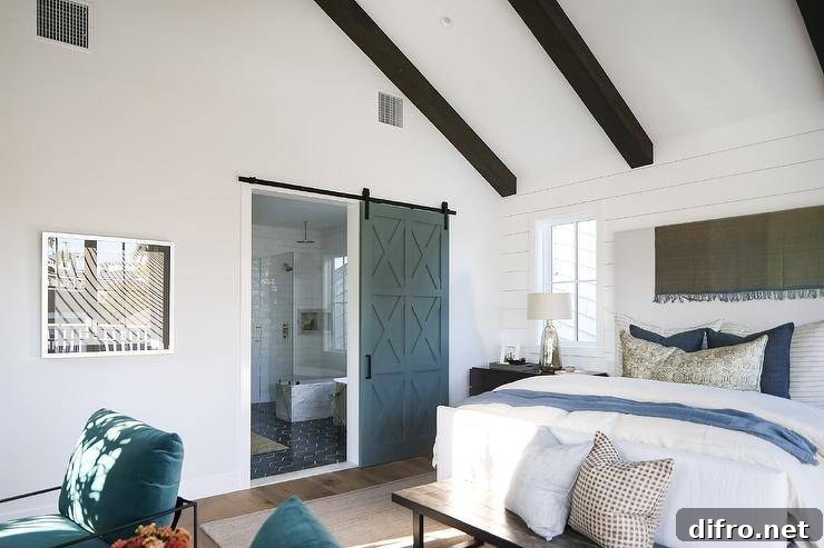 Blue sliding barn door opening to an en suite bathroom