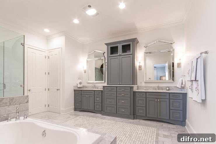 Marble tub and gray cabinetry in an elegant master bathroom