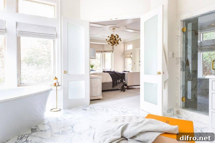 Marble tiled floor with frosted glass doors opening to a freestanding tub