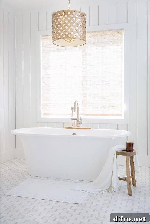 Vintage oval tub with pendant light over marble floor