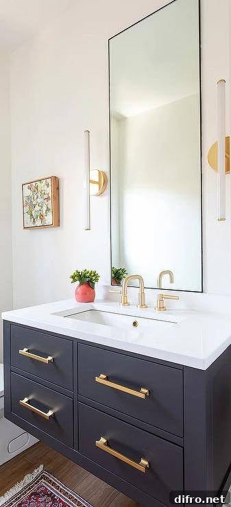 Bathroom features gold pulls on a black floating sink vanity with a white countertop and a brushed gold gooseneck faucet under a tall black vanity mirror flanked by long white and brass sconces.