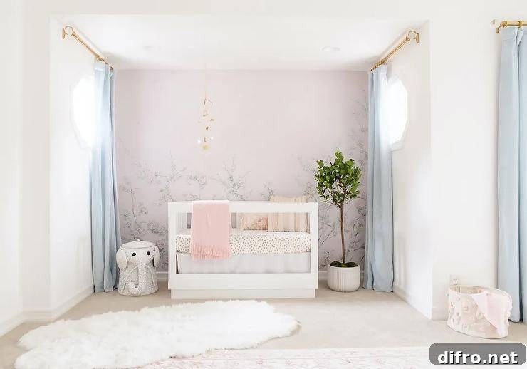 Nursery features a pink floral mural on accent wall with a gold mobile sits over a white wooden nursery crib with animal print bedding, baby blue curtains, a white wicker elephant hamper and a large white faux fur rug.