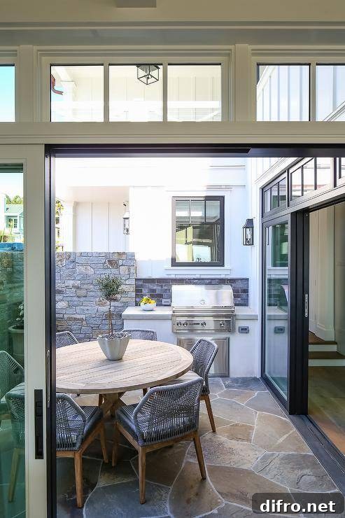 An outdoor kitchen with a light gray concrete countertop beside sliding glass doors.