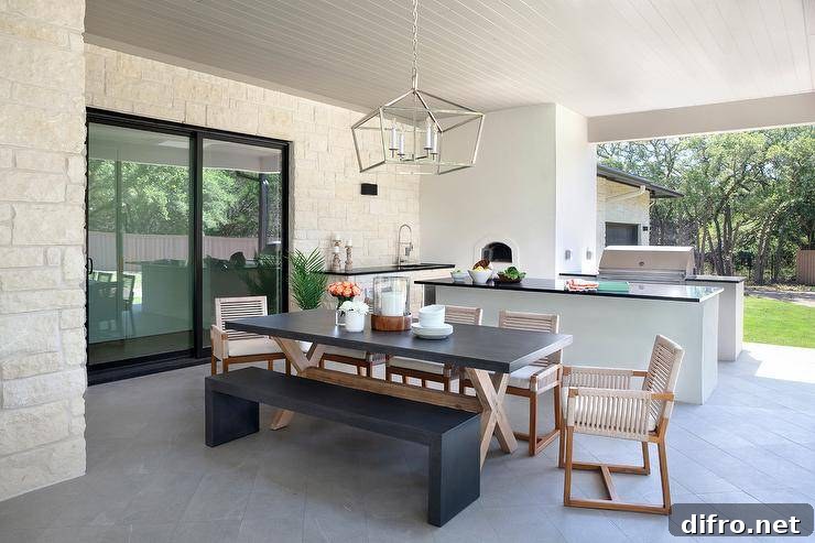 Light gray chairs around a concrete dining table on a covered patio.