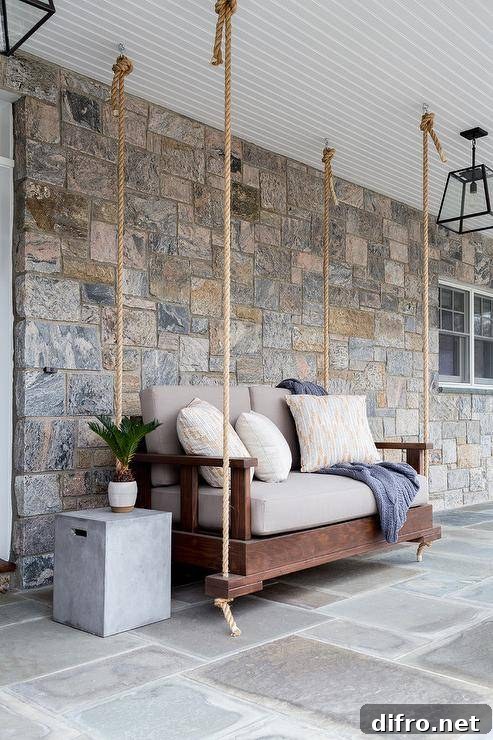 A wood and rope hanging sofa beside a concrete end table.
