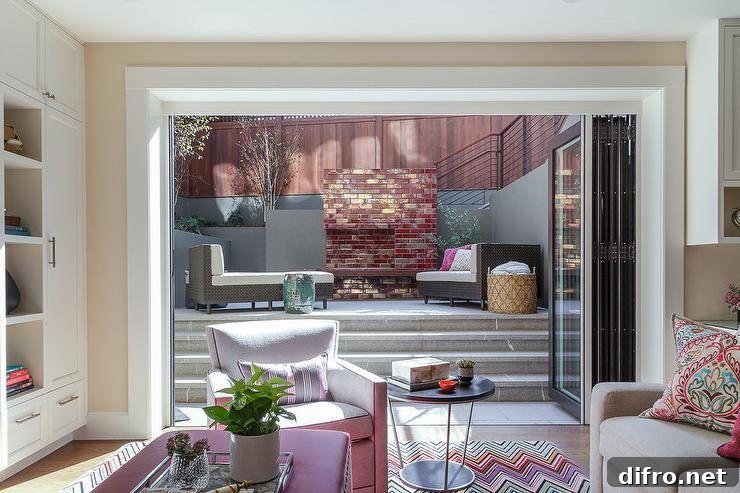 Folding glass doors open to a patio with concrete steps leading to wicker loungers.