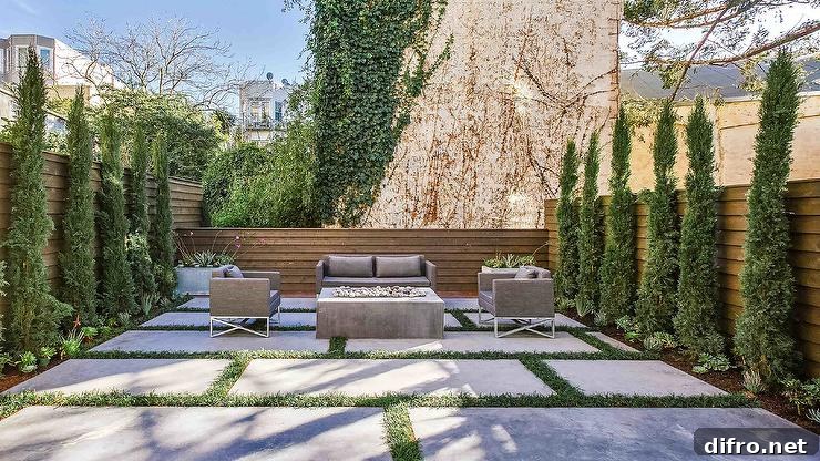 Patio features large concrete pavers with grass trim and a concrete rectangular fire pit.