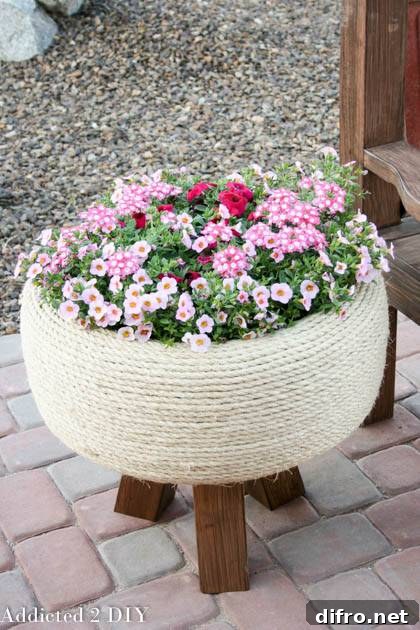 jute wrapped tire planter with spring flowers on patio