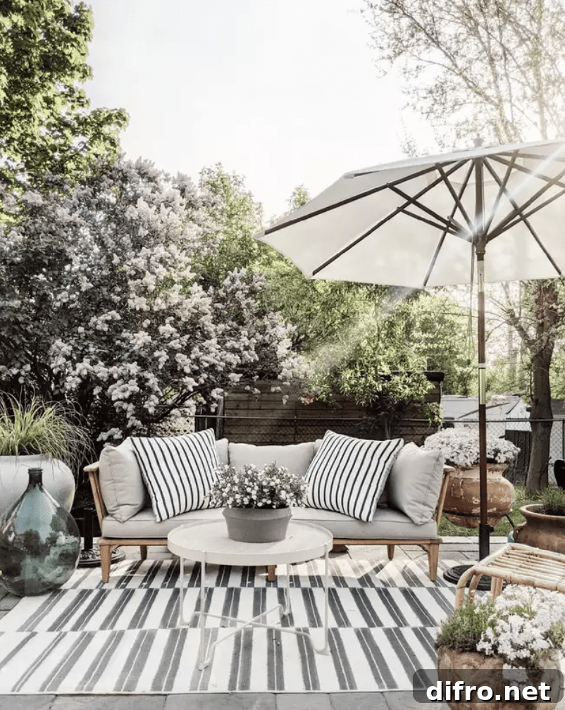 outdoor patio with black and white stripe rug umbrella and outdoor couch
