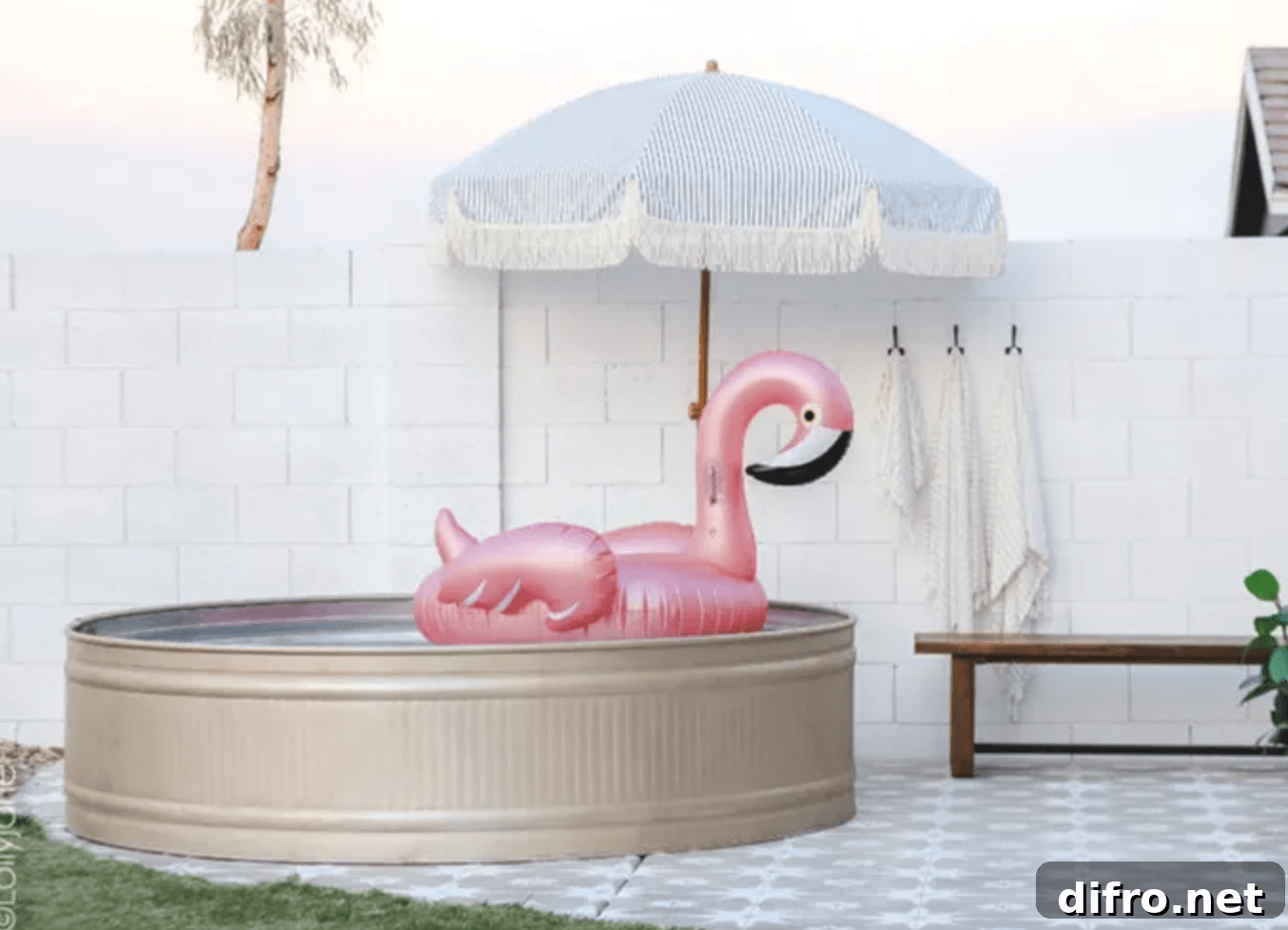 stock tank pool with umbrella and inflatable pink flamingo