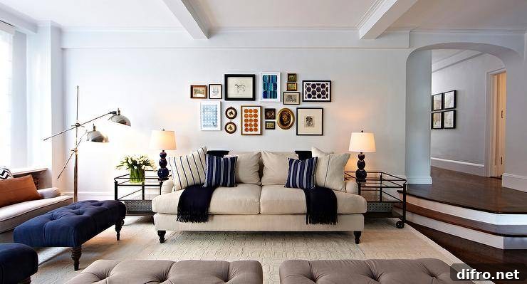 Living room with collage of modern and vintage artwork and built-ins with blue backs.