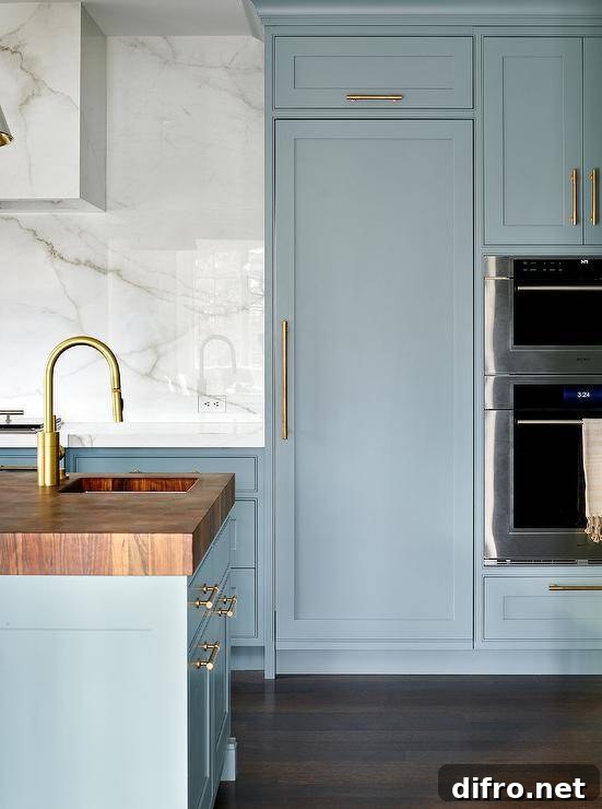 A butcher block countertop accents a blue kitchen island finished with a sink and a polished nickel gooseneck faucet.