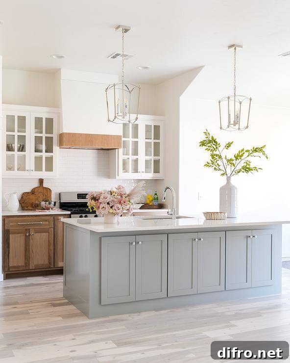 Light stained wood floors frame a gray kitchen island with storage.