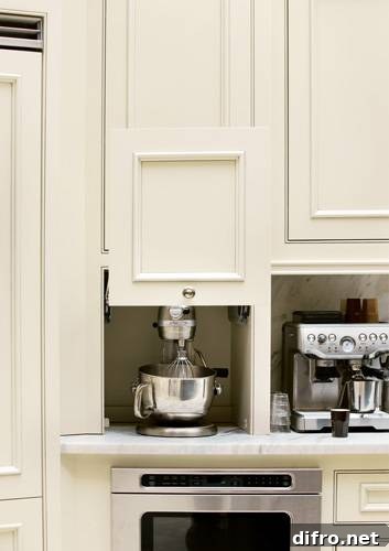 Appliance garage with slide-up cabinet front hiding a mixer and built-in microwave.