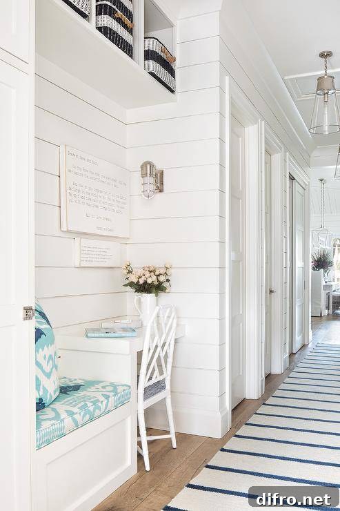 A blue stripe rug lines a cottage hallway with a white built-in desk