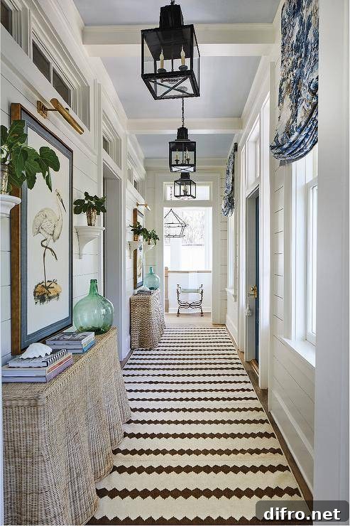 Carriage lanterns light a long cottage hallway with burlap skirted console tables