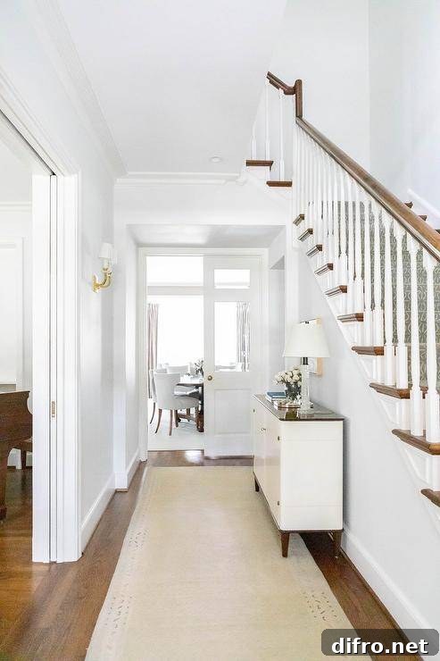 Hallway features a white and brown cabinet over a cream runner