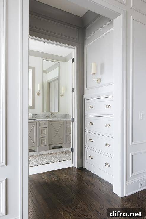 A sconce illuminates built-in hallway drawers accented with polished nickel cup pulls