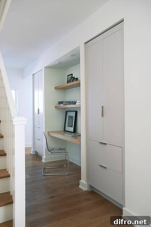 Foyer alcove features a wood floating desk under stacked floating shelves