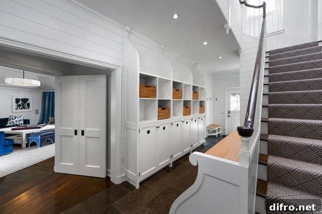 Entryway features built-in mudroom storage with open cubbies lined with woven storage bins