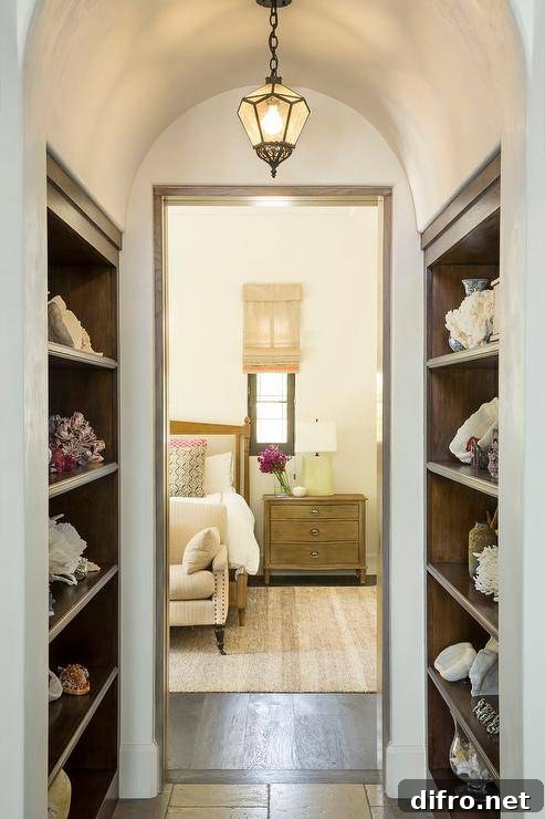 Hallway with an antique pendant hung from a barrel ceiling between facing built-in wood shelves