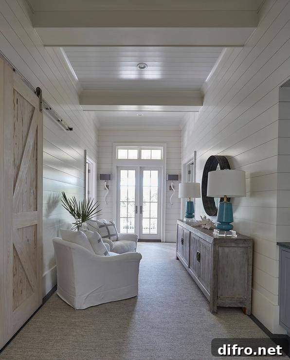Beach style hallway with a gray wash cabinet topped with blue lamps tucked under a black convex mirror