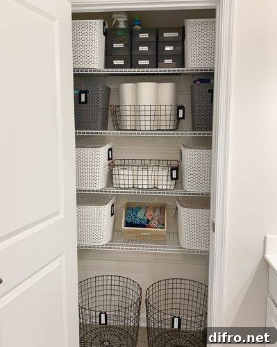 organized linen bathroom closet with wire baskets and plastic totes paper towel toilet paper