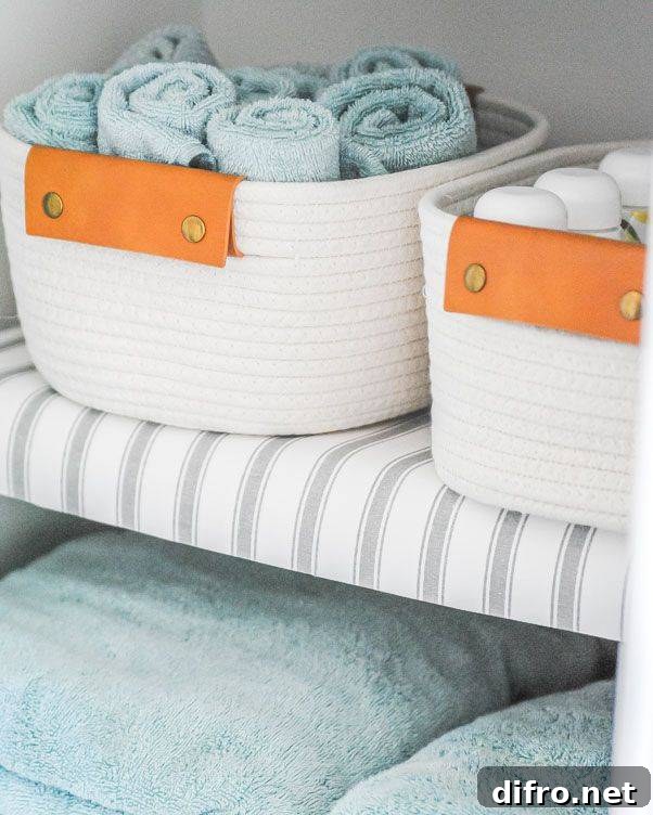 shelf liners on wire shelf with white rope baskets and rolled blue towels