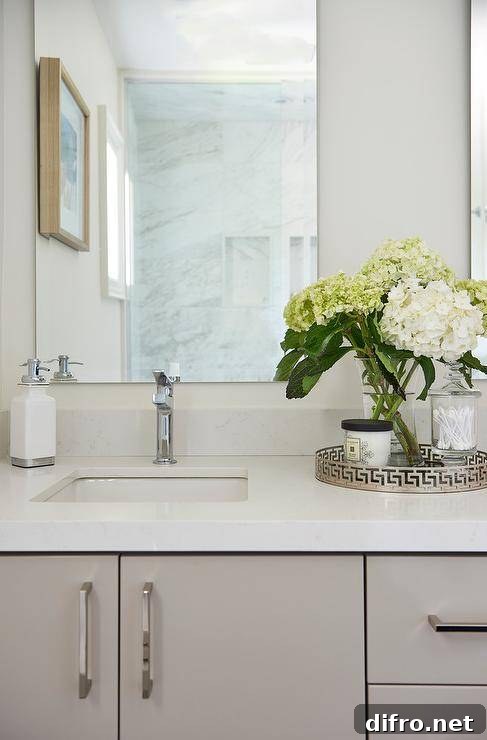 Decorate a bathroom vanity with a round greek key tray to hold decor while adding visual interest atop white quartz countertops.