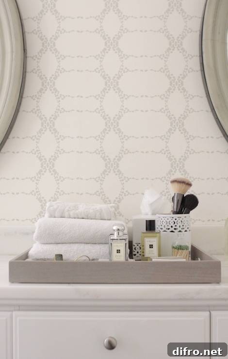 Lovely bathroom features a white bathroom vanity topped with white marble countertop and gray tray.