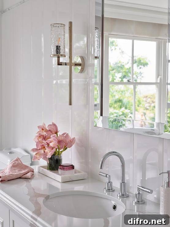 Bathroom features a chrome beveled mirror on a glossy white vertical plank wall over a marble tray on a marble look countertop.