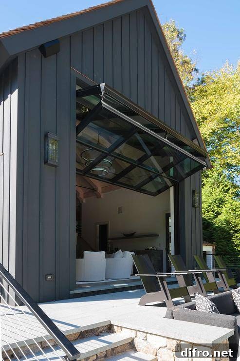 Gorgeous black pool house is finished with a glass garage style door.