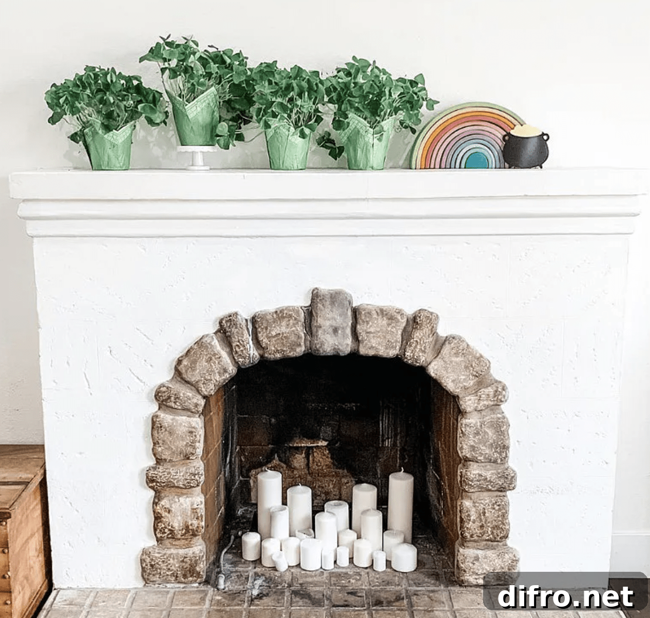 white fireplace with pillar candles and greenery on the mantel