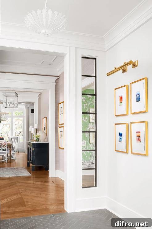 A brass picture light is mounted to a white wall over gold gallery frames.