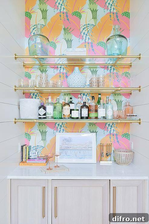 Living room bar nook with blue, orange and pink wallpaper features glass and brass pipe plumbing shelves.