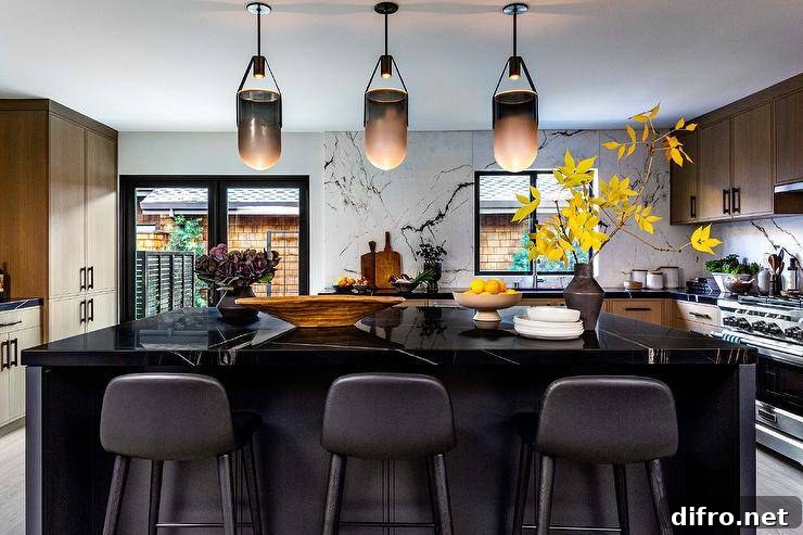 Black center island lit by modern black and white pendants is topped with a black marble countertop paired with black leather stools.