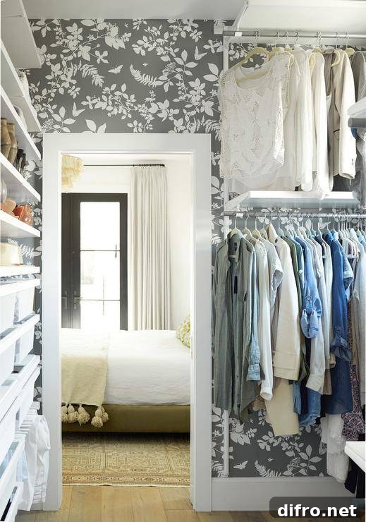 Walk-in closet with charcoal floral wallpaper and modular shelving.
