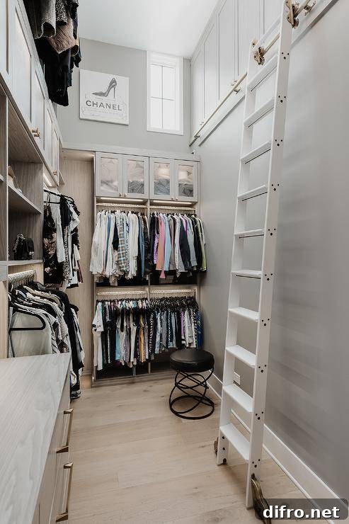 Walk-in closet features a white ladder on rails and tall shelving.