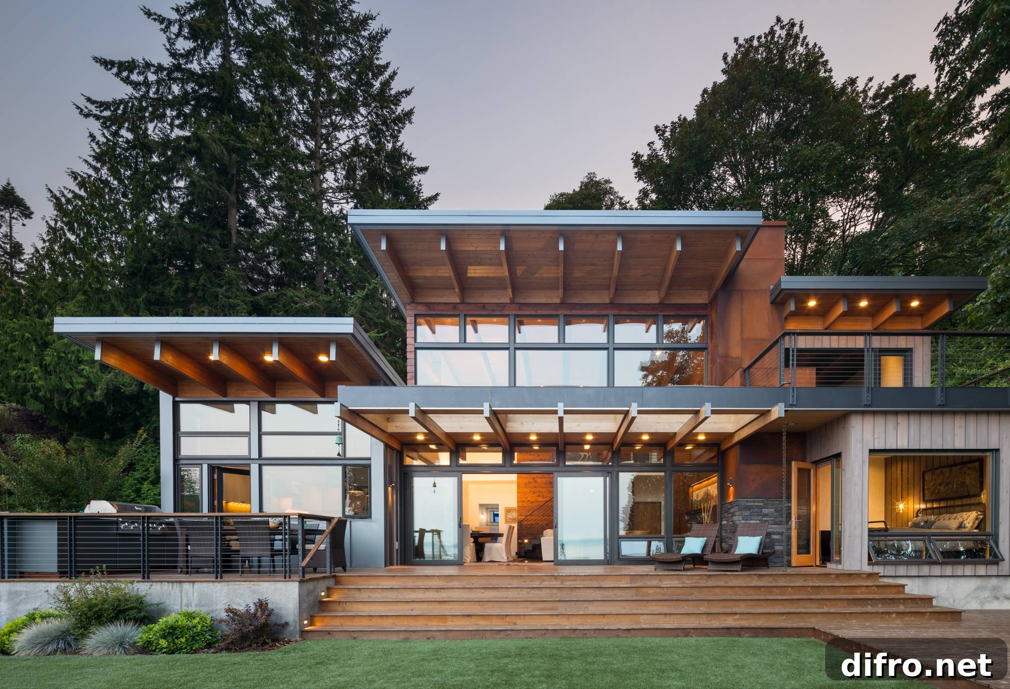 metal and wood framed cabin home with large windows and large wooden deck
