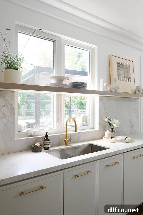 marble slab backsplash and light gray cabinets with a stainless steel sink