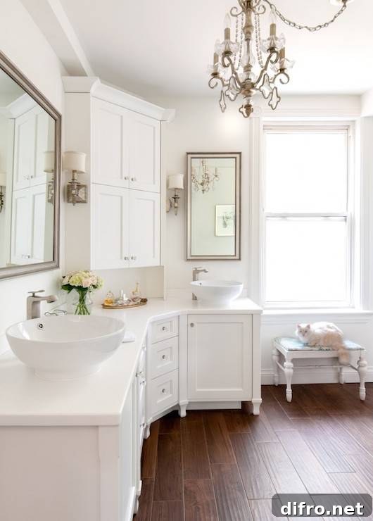 White bathroom with curved cabinets and dual bowl sinks flanking a corner console