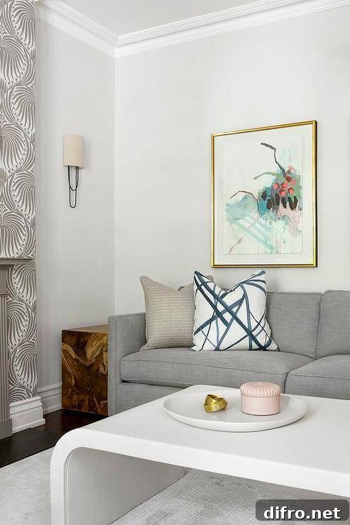 Living room features a gray couch with a white waterfall coffee table and a burl wood cube end table.