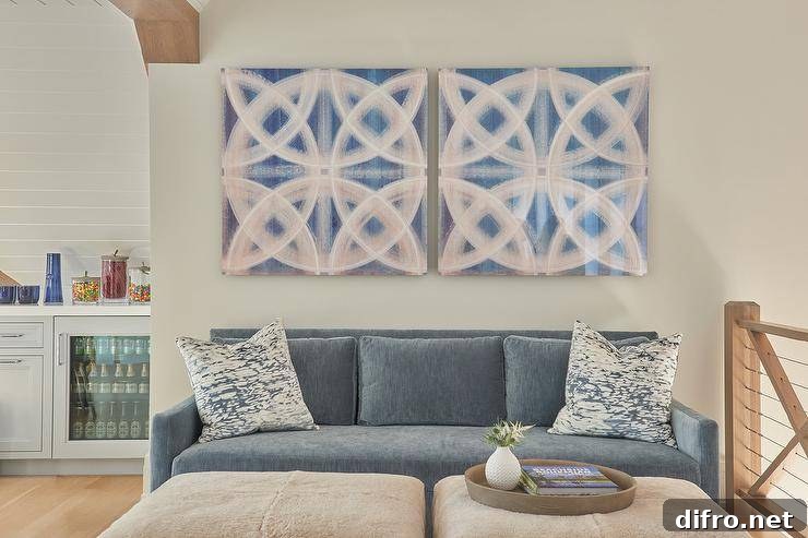 Blue velvet sofa topped with white and blue pillows positioned facing cream wool ottomans.