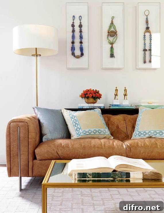 Modern brown leather tufted sofa accented with cream, blue and silver pillows in a contemporary living room.