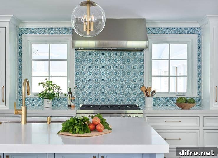 Stainless steel range hood mounted against blue mosaic backsplash