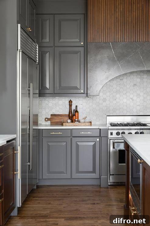 Curved marble range hood paired with charcoal cabinets and hexagon tiles
