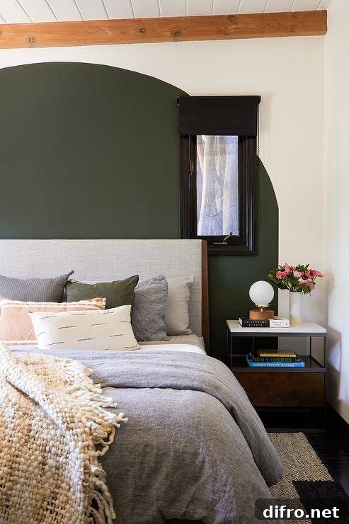 Arched green accent wall behind a vintage headboard
