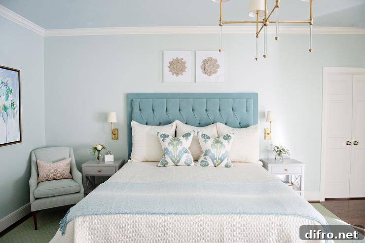 Restful bedroom with light blue walls and blue velvet headboard