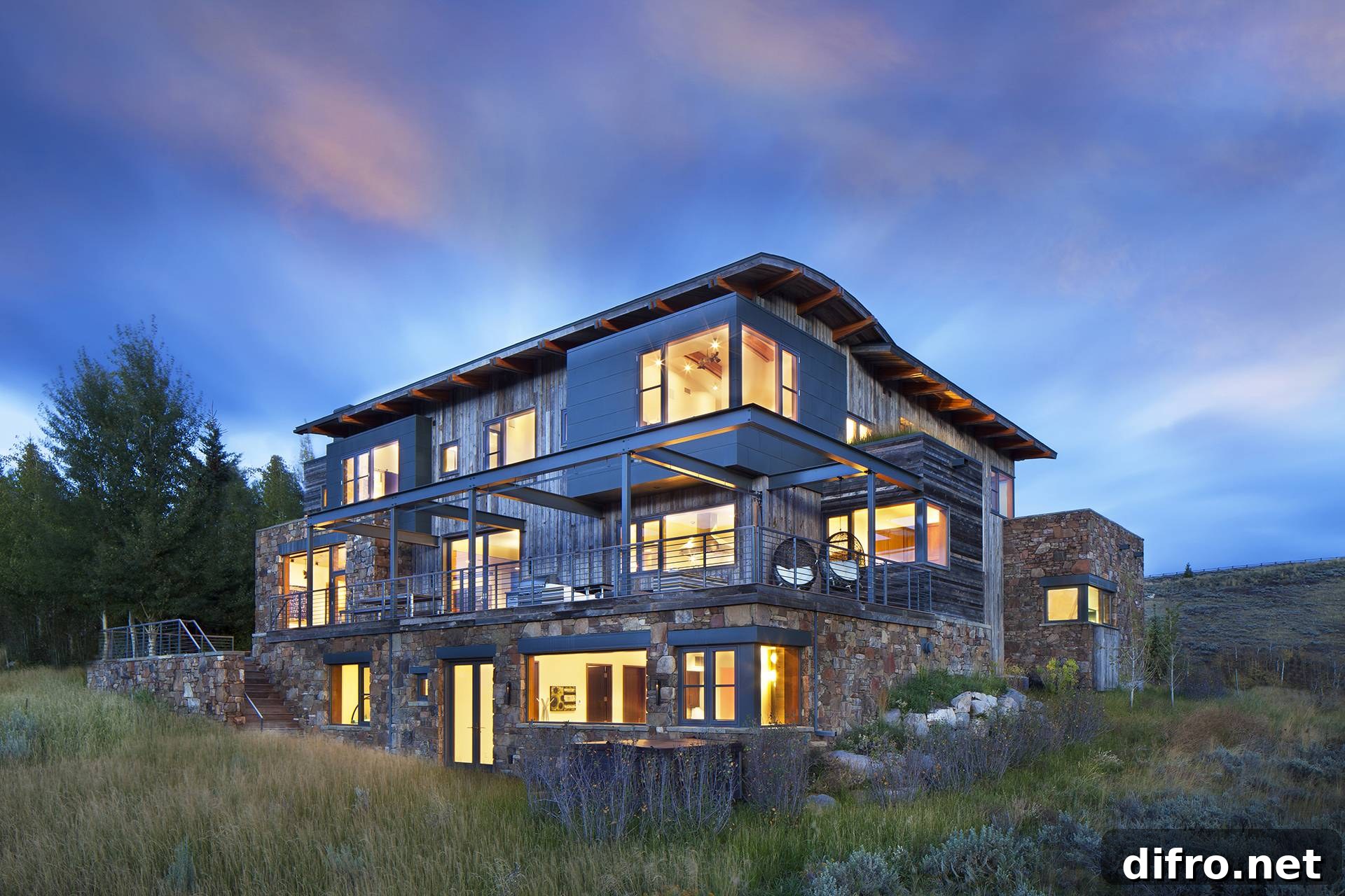 exterior of wood and stone home at sunset with lit up windows