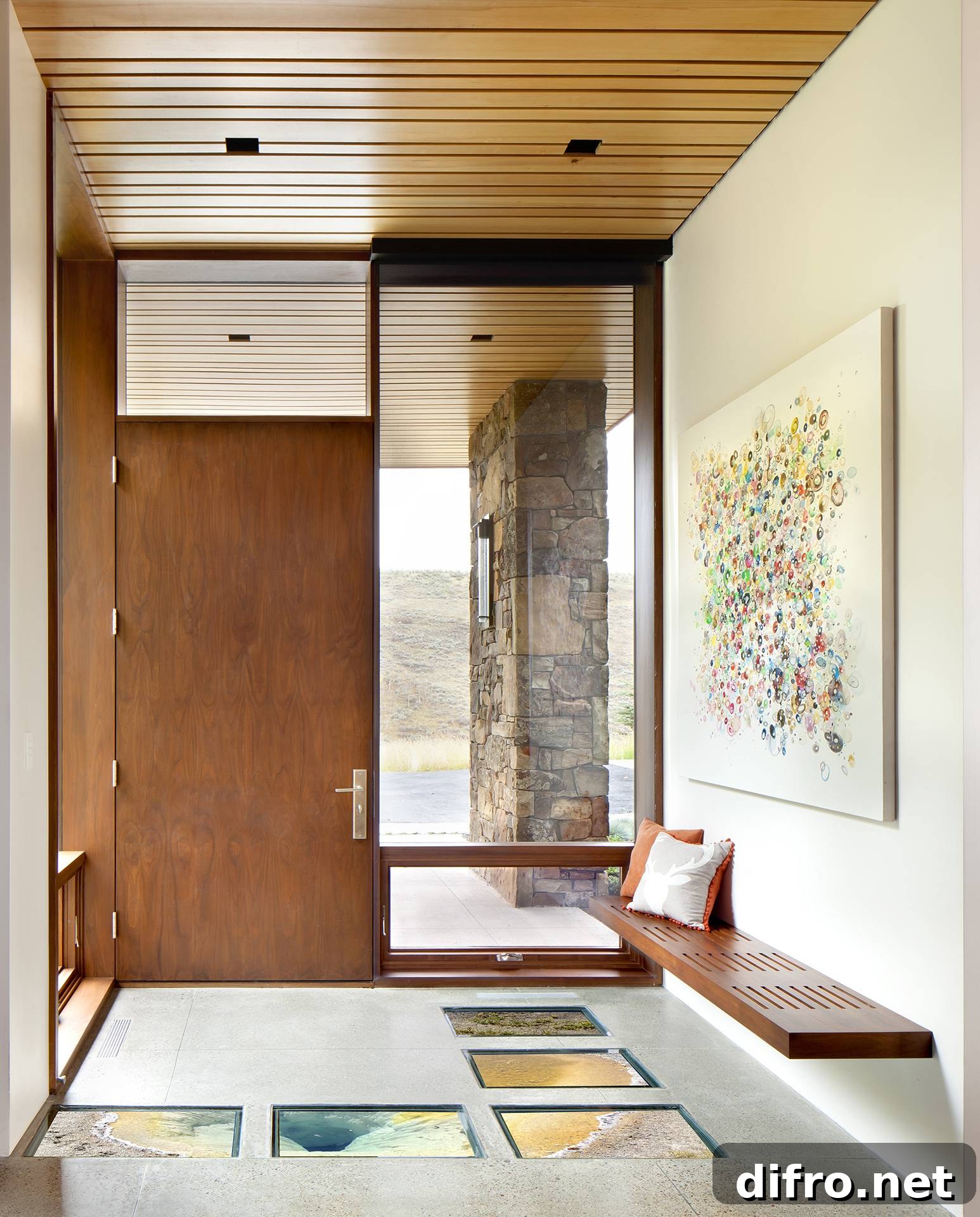 wooden front door in foyer with large windows and glass accents on floor